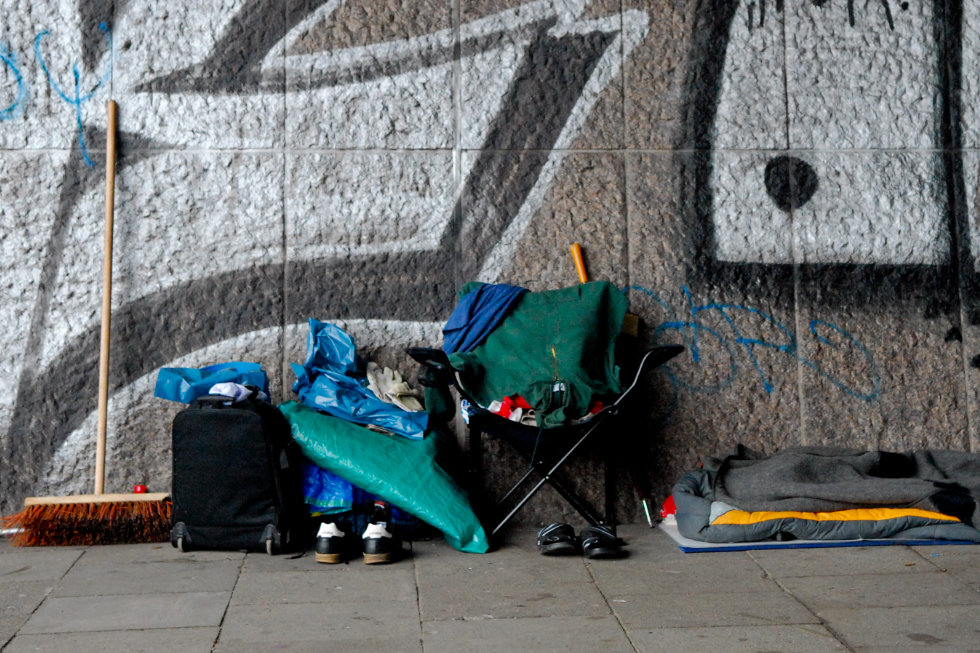 Wohnstätte einer obdachlosen Person vor einem Graffiti