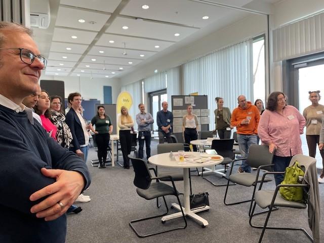 Teilnehmende stehen in einer Runde beim Markttag