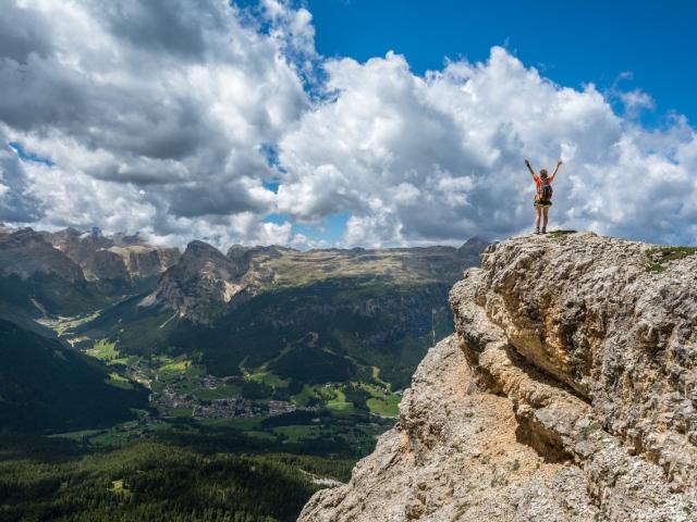 Wanderin auf einem Felsen in Siegespose